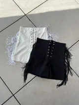 Short negro de bengalina elastizada con cintura alta, cordones cruzados en el frente y flecos en los laterales.