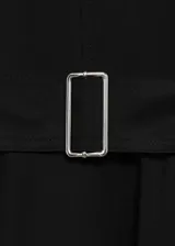 Vestido midi negro con escote en V, mangas cortas tipo kimono, falda acampanada con corte asimétrico y cinturón con hebilla metálica.