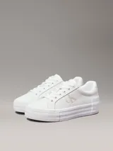 Zapatillas urbanas Calvin Klein Jeans de cuero sintético color blanco, con plataforma plana, cordones y logo CK en el lateral.