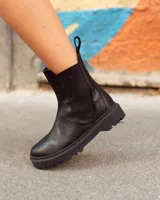 Bota de cuero color marrón con elásticos laterales negros, caña baja y suela negra artesanal de neolite.