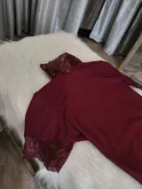 Body entallado de lycra color bordo con detalles en microtul y encaje. Con cuello alto y espalda descubierta.