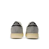 Championes New Balance T500 unisex, color gris y blanco, con detalles en negro. Confeccionados en ante y nobuk de piel de cerdo, con detalles perforados en la puntera y entresuela de goma.