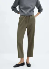 Pantalón color verde oliva, de tejido fluido, corte recto, tiro alto, cintura elástica con cordón de ajuste y bolsillos laterales.