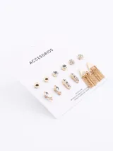 Set de seis pares de aros dorados con diferentes diseños: bolitas, strass, flores y colgantes con flecos.