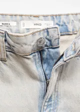 Pantalón de jean celeste claro, de corte recto, tiro medio y bajo desflecado.