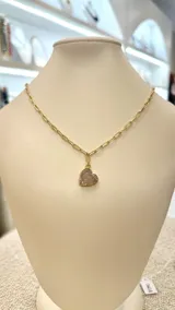 Collar con cadena dorada y dije de cuarzo rosa en forma de corazón.