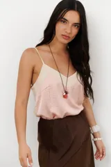 Musculosa de tirantes delgados con diseño bicolor: la parte superior es de color crema y la parte inferior es de color rosado pálido, ambas con acabado satinado.
