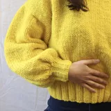 Buzo amarillo tejido a mano con lana merino.