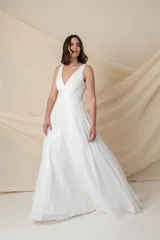 Vestido largo blanco de gasa, con corsé armado y falda con caída desde debajo del busto.