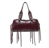 Bolso tipo bowling color borgoña, con doble asa corta con detalle de trenzado y flecos colgantes.