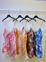 Musculosa con breteles finos, de satén con estampado abstracto en tonos rosados y blancos.