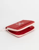 Billetera de cuerina color blanco con estampado de corazones rosas y lazos azules, cierre perimetral con cremallera y múltiples ranuras para tarjetas.