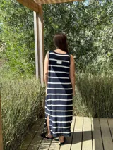 Vestido largo tejido a rayas horizontales azul marino y blancas, sin mangas, con cuello redondo y tajos laterales.