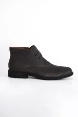 Bota de cuero color marrón oscuro, de caña media, con cordones y suela plana.