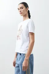 Remera blanca de algodón con estampa de motivos playeros en tonos marrones.