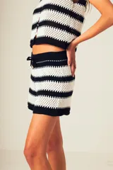 Short tejido a crochet con rayas horizontales en blanco y negro, con cintura elastizada y cordón ajustable.