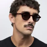 Gafas de sol redondas con montura carey y lentes negras polarizadas. Fabricadas con material bio-based G850 y patillas de propionato de celulosa. Protección UV400.