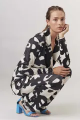 Blazer con estampado abstracto en blanco y negro, con solapas de muesca, cierre con dos botones y corte recto.