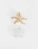Set de dos broches para el pelo, uno dorado con forma de estrella de mar y otro transparente con forma de flor.