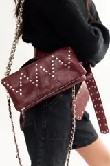 Cartera de cuero color rojo con diseño en zigzag de tachas, con asa doble para usar como bandolera o cartera de hombro.