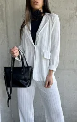 Blazer blanco con rayas, de corte clásico y cierre frontal, con bolsillos laterales.
