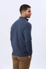 Buzo tejido de punto color azul marino, con cuello alto y medio botón frontal. Presenta un patrón texturizado y puños y dobladillo acanalados.