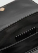 Bandolera color borgoña con correa de cadena dorada, cierre de solapa con botón magnético y logo en relieve.