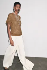 Top marrón de tejido crochet con cuello barco y manga corta.