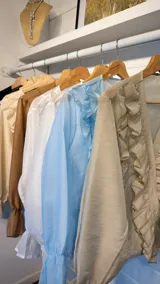 Camisa celeste de organza con volados en el frente y mangas largas abullonadas.