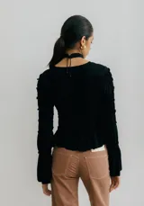 Top negro fruncido con mangas largas acampanadas.