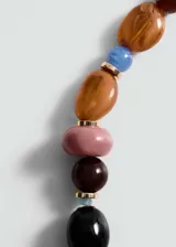 Collar corto con cuentas de diferentes tamaños y colores: rosa, marrón, azul, negro y naranja. Cierre de mosquetón con cadena de alargue dorada.