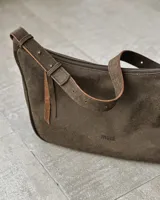 Cartera bandolera marrón de cuero con correa ajustable.