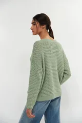 Sweater verde claro de tejido de punto calado con escote en V y mangas largas.
