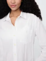 Camisa blanca de lino con cuello clásico, manga larga y bolsillo en el pecho.