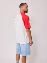 Remera azul marino con mangas raglán color crema y estampado frontal con el logo de Rusty en blanco.