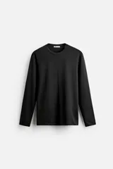 Camiseta negra de manga larga y cuello redondo, corte slim fit.