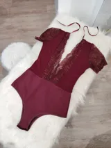 Body de lycra color borgoña con encaje floral en escote y mangas cortas. Breteles finos ajustables.
