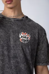 Remera gris con efecto acid wash, corte holgado y estampa frontal con una mano sosteniendo el mundo VCP.