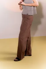 Pantalón marrón de lino rústico, con calce recto y tiro medio. Tiene bolsillos delanteros y traseros.