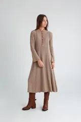 Vestido midi de punto color visón con cuello redondo y mangas largas acampanadas.