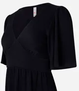 Vestido corto negro de malla texturizada, con escote en V, mangas cortas godê y volado en el bajo.