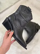 Botas cortas negras de cuero con punta fina, taco cuadrado y apliques de tachas plateadas.