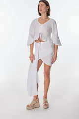 Conjunto de camisa celeste de mangas largas abullonadas y falda turquesa con detalle fruncido y lazo en el lateral.