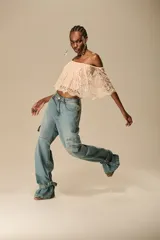 Pantalón jean celeste de corte ancho, con bolsillos cargo laterales y puños ajustables con hebillas.