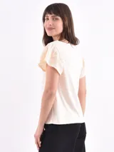 Remera blanca de manga corta con cuello redondo y detalle de bordado inglés en el canesú y los bordes de las mangas.