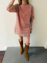 Vestido corto de lurex color salmón con brillo, escote redondo y mangas largas abullonadas. Incluye lazo para marcar la cintura.