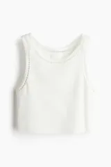 Musculosa cropped blanca de punto de algodón acanalado con corte ajustado e inserciones de encaje en escalera en escote y sisas.