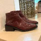 Botas cortas de cuero color borgoña con textura tipo piel de reptil, taco cuadrado y punta fina. Cierre lateral.