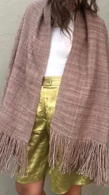 Ruana de lana merino tejida artesanalmente en telar, de color visón con diseño recto y terminación de flecos en los extremos.