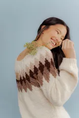 Sweater tejido en lana merino color crudo, con diseño geométrico en tonos marrones en la parte superior.